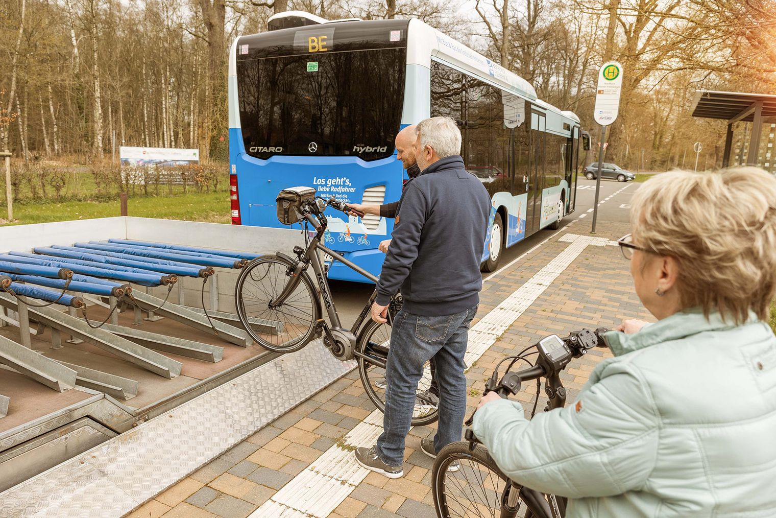 Leute schieben ihr Fahrrad auf den Anhänger des Fietsenbus.