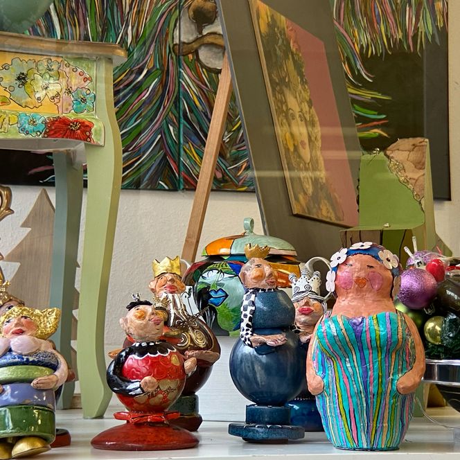 Schaufenster mit lustigen kleinen modelierten Damen und Herren und allerlei Kunst.