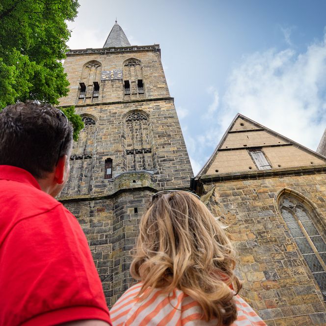 Ein Paar blickt hinauf zum Kirchturm der evangelisch reformierte Kirche.